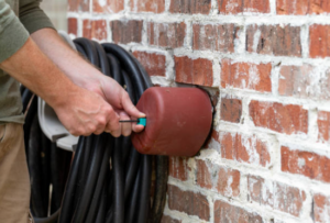 Image of hands installs faucet cover to protect pipes from freezing weather